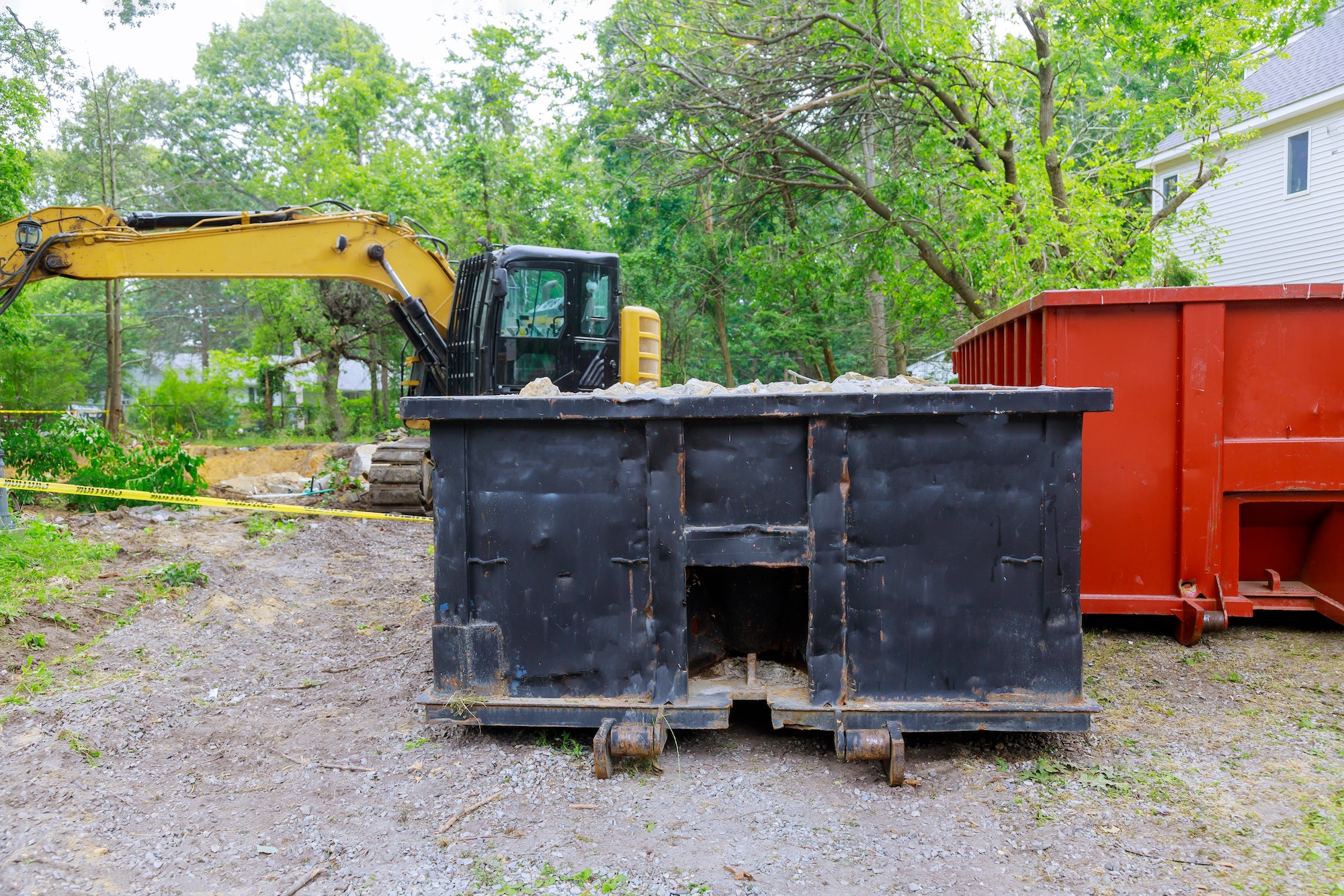 Industrial dumpster filled loaded rubbish removal container renovation building on house under